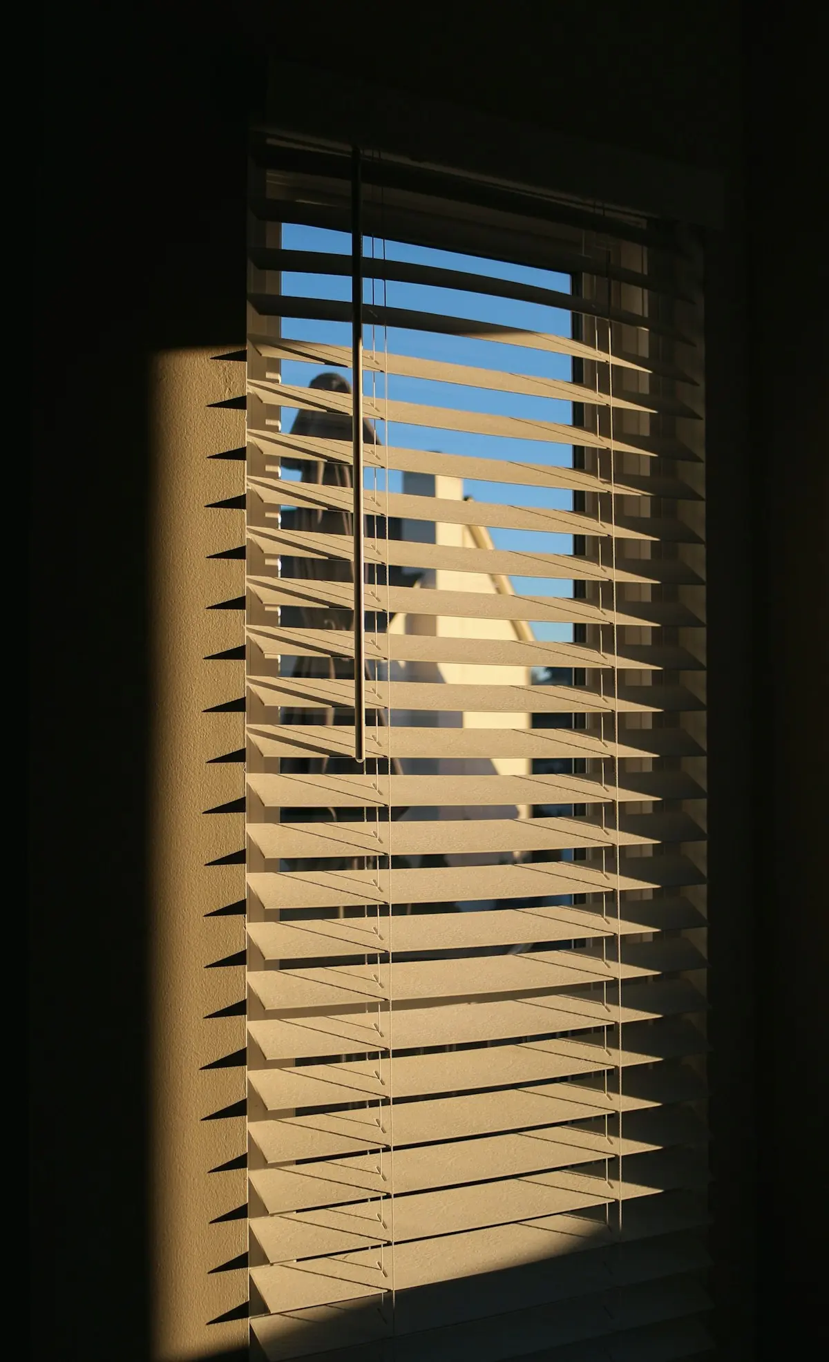 How to Clean Blinds Without Spreading Dust and Pollen Otevřené žaluzie u okna v teplém denním světle, které připomínají jarní větrání a pylovou sezonu.