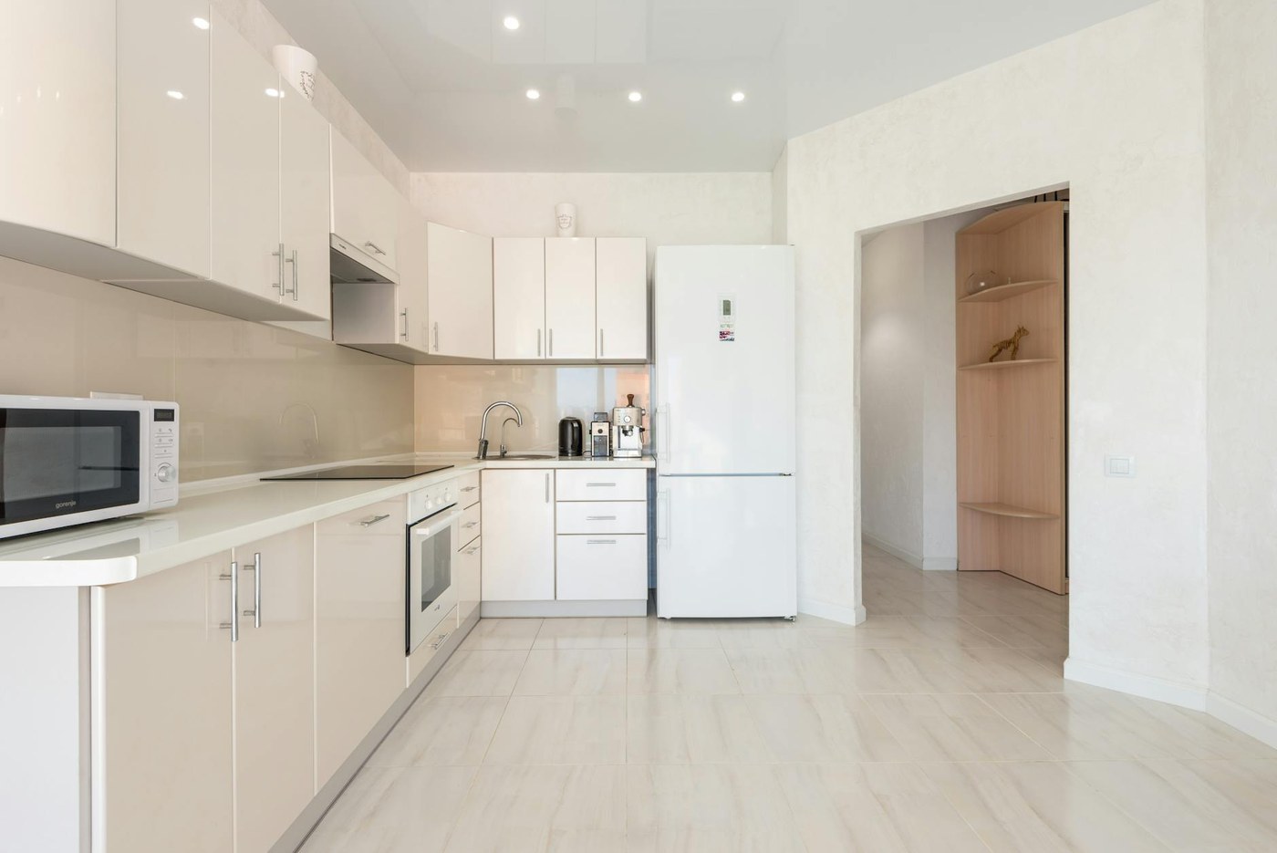 A clean kitchen in an empty rental flat with polished worktop and checked appliances