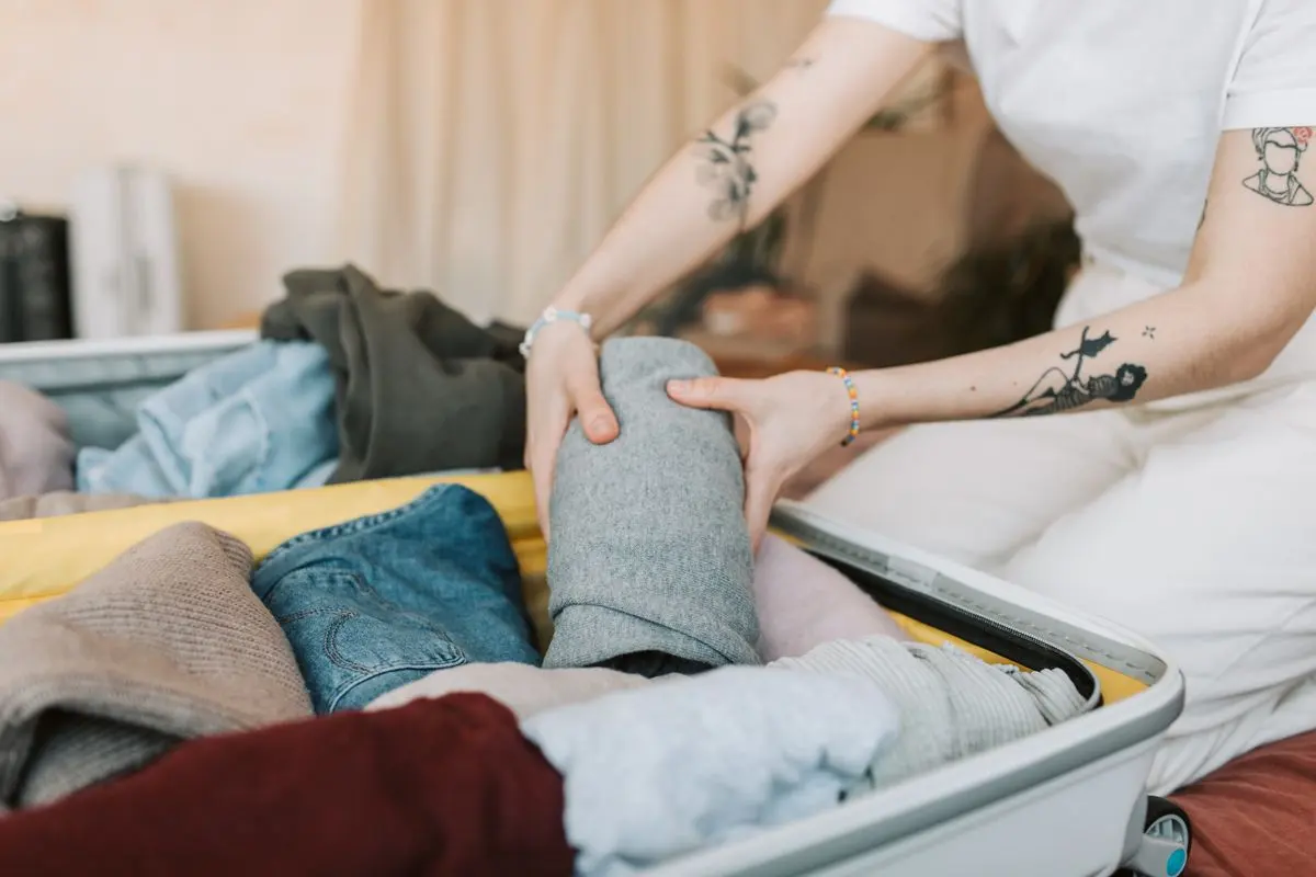 Detailní záběr na vybalování věcí z kufru a jejich systematické ukládání