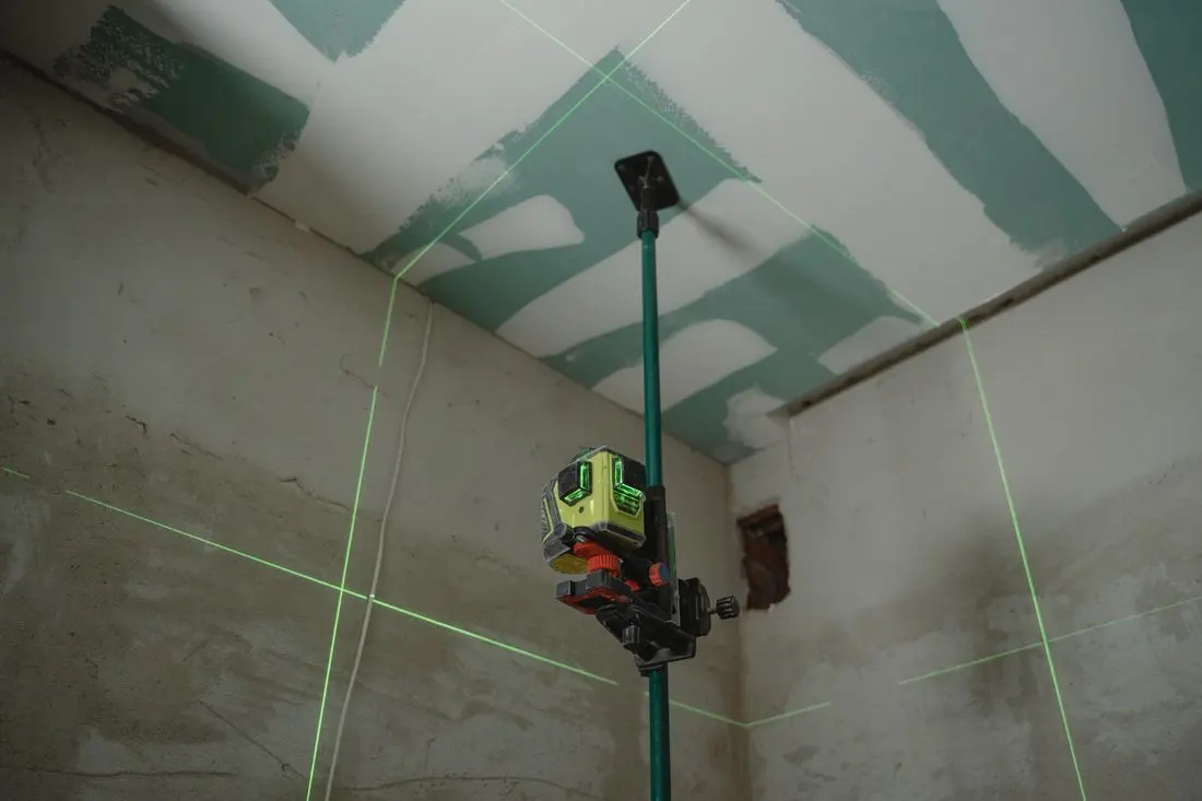 Detail smetáku a lopatky při odstraňování prachu z dřevěné podlahy po stavebních pracích.