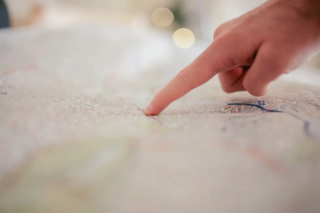 Ruka ukazuje na městské čtvrti v mapě při plánování obslužných zón.