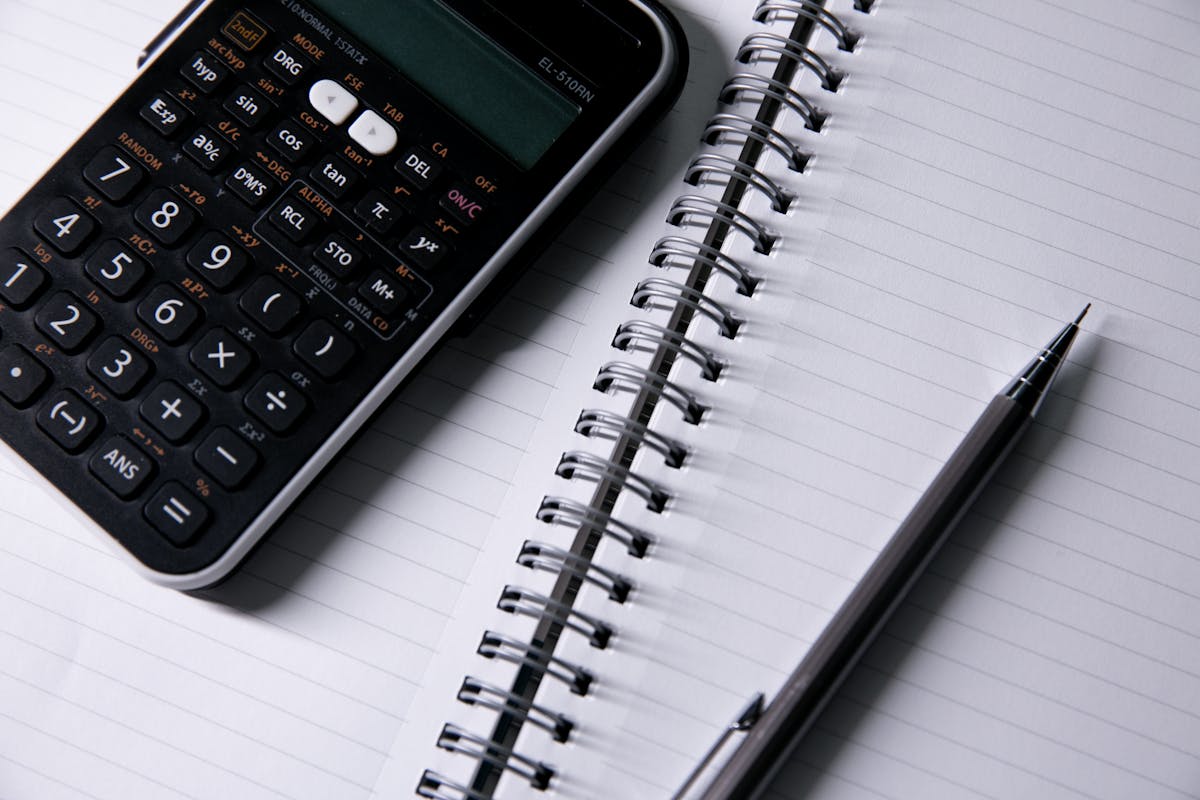 Notebook and calculator used to compare hourly and flat-rate pricing models