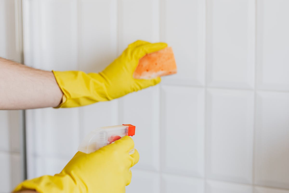 Detailed bathroom cleaning in gloves as an example of work that often sits outside the basic scope