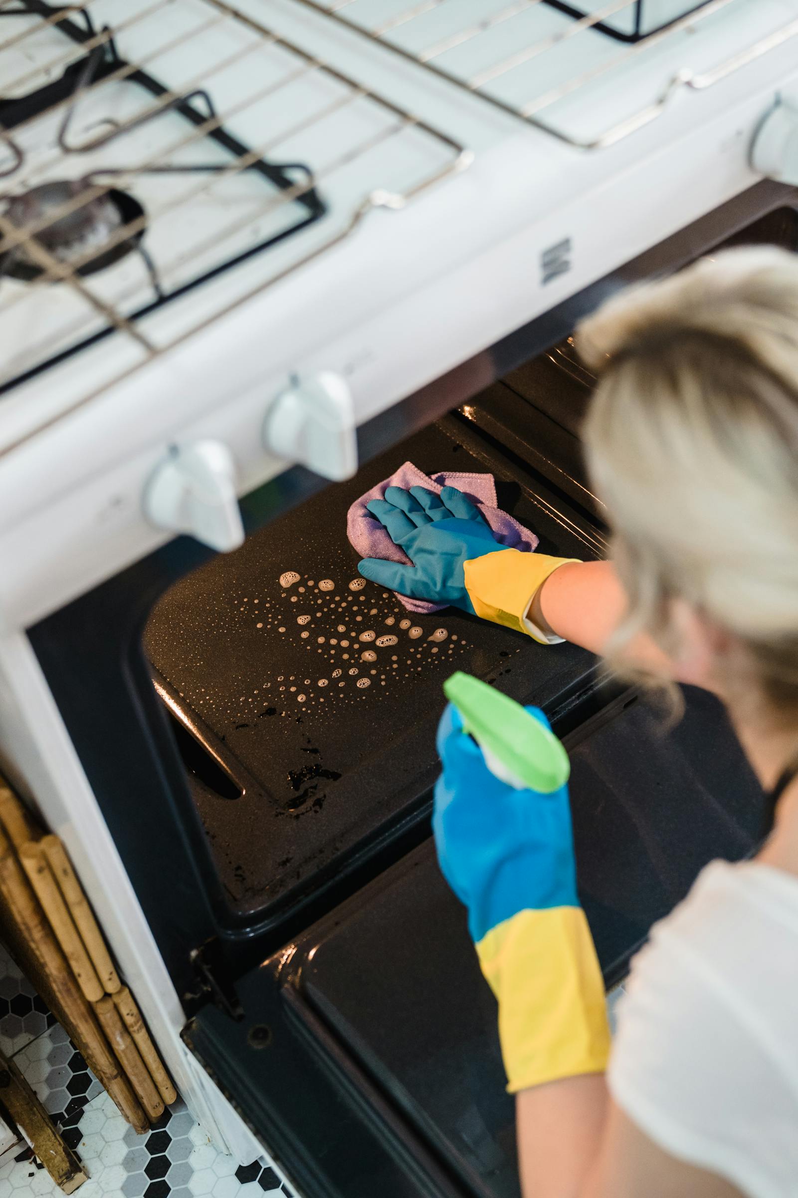 Removing oven racks before a deep clean in a home kitchen