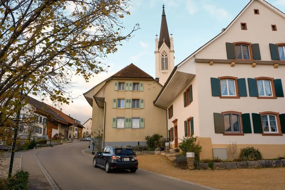Ulice menšího města s autem, které může zajistit dojezd za úklidem v okolí