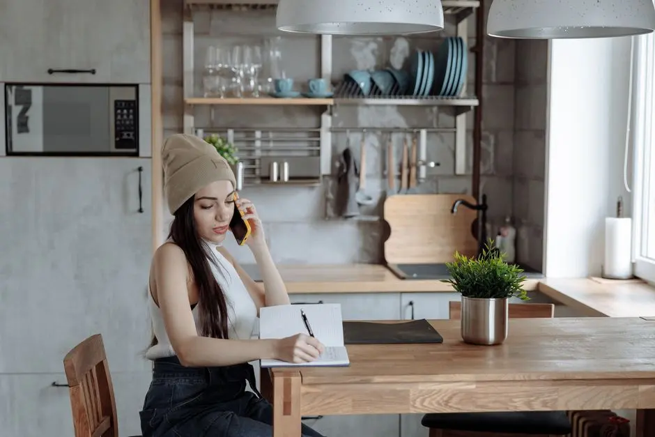 Žena si při telefonátu zapisuje podrobnosti poptávky na úklid domácnosti