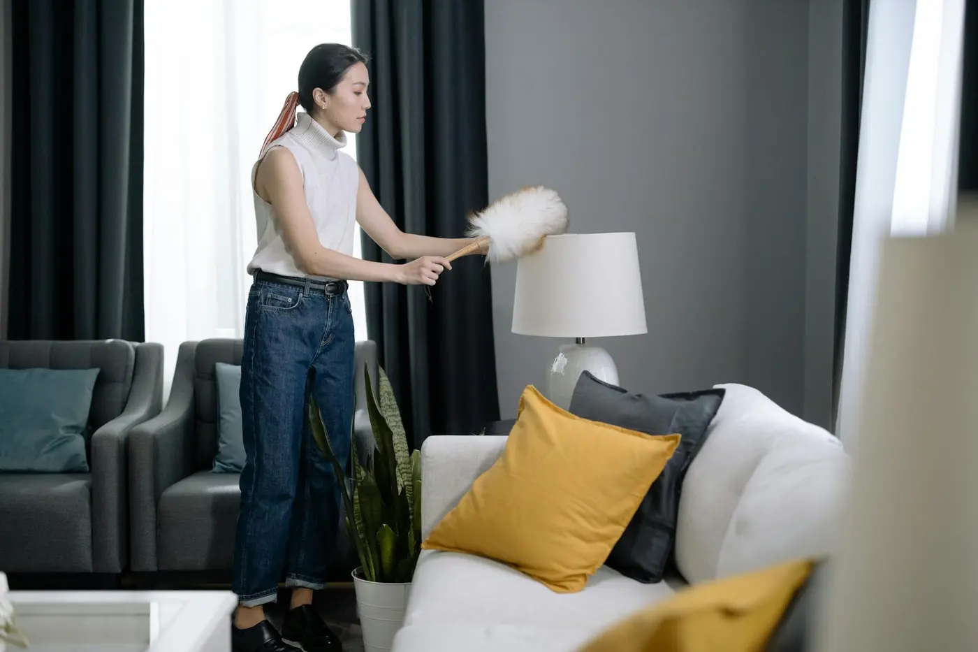 Post renovation cleaning pricing without losing margin Detailní oprašování lampy v moderním bytě po rekonstrukci, kde se jemný prach usazuje i mimo podlahu.