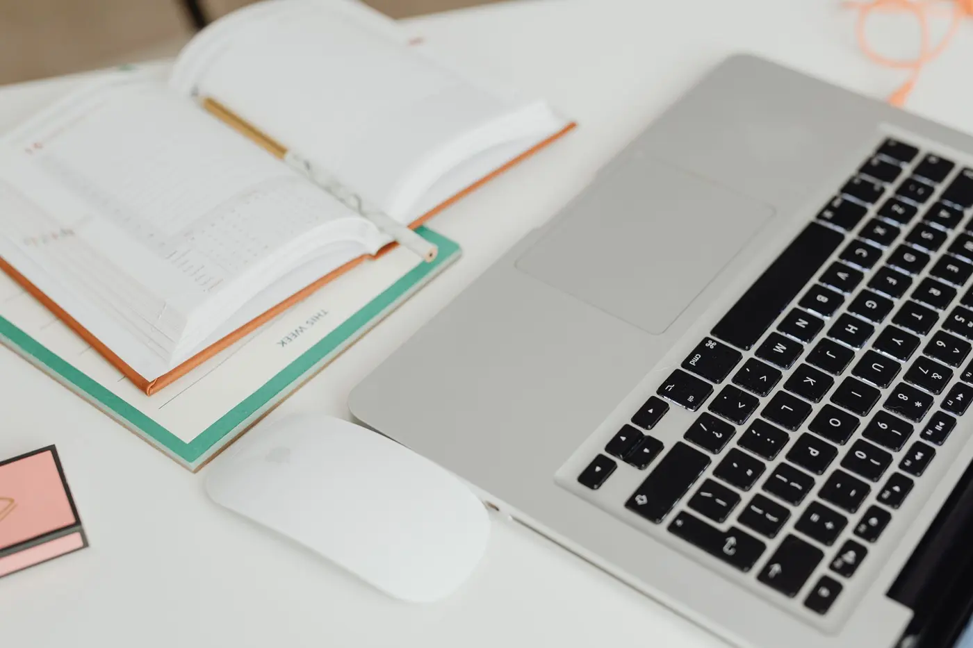 Notebook, kalendář a počítač pro týdenní sledování výsledků poptávek