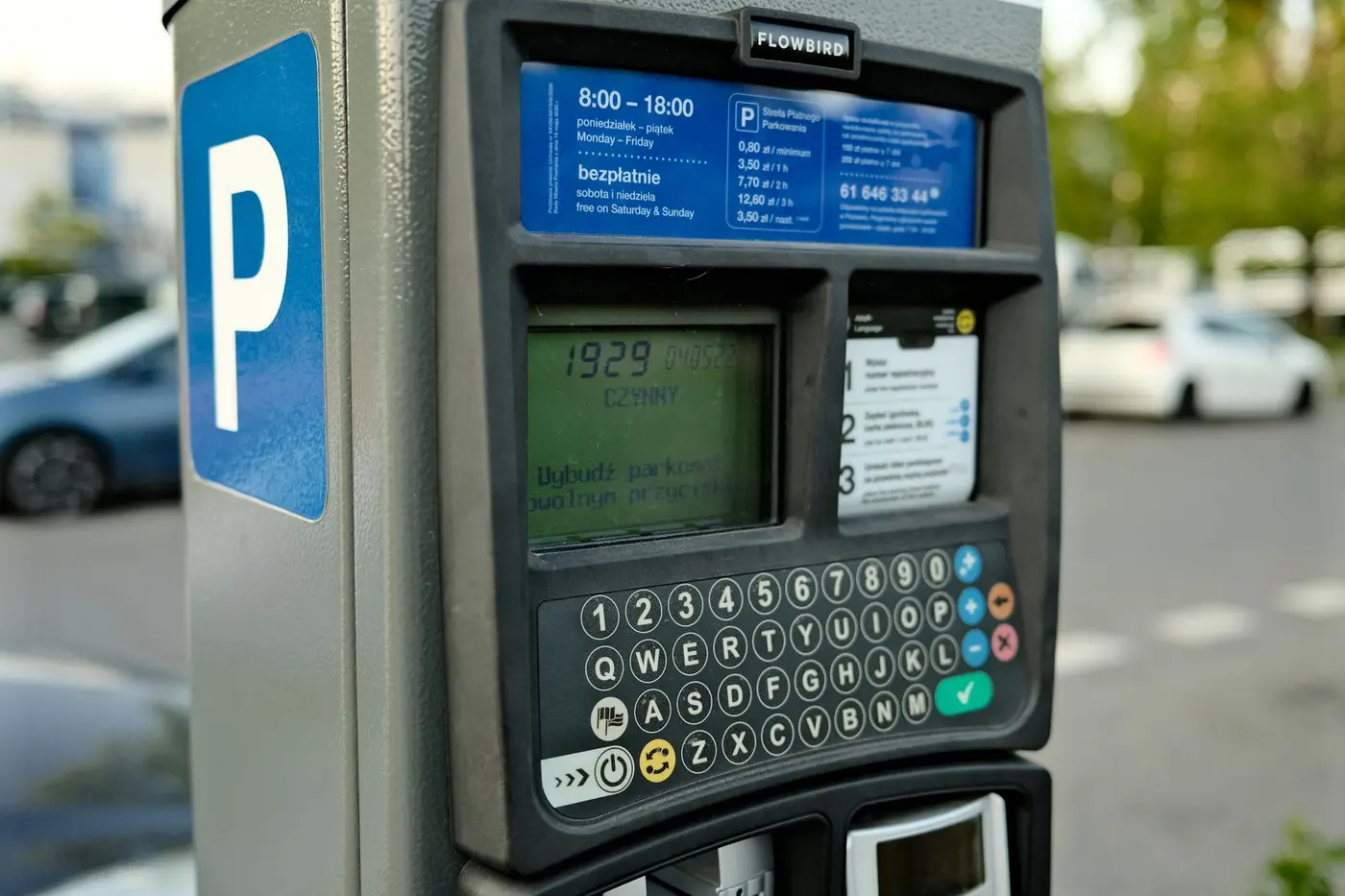 Parkovací automat u zaparkovaných aut připomíná náklady na výjezd za úklidem ve městě.