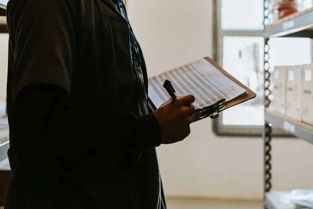Ruka označuje splněné body na pracovním checklistu připraveném pro jednotný postup úklidu.