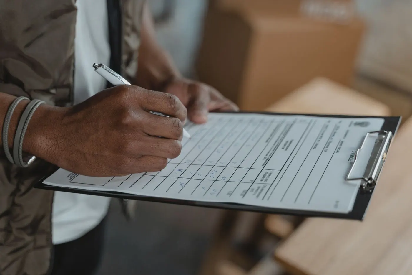 Detail ruky vyplňující kontrolní checklist stavu apartmánu