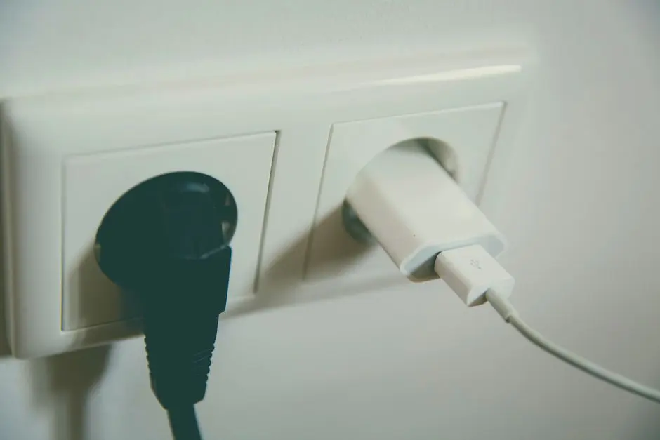 Detail elektrických zástrček v zásuvce, připomínající důležitost vypojení spotřebičů