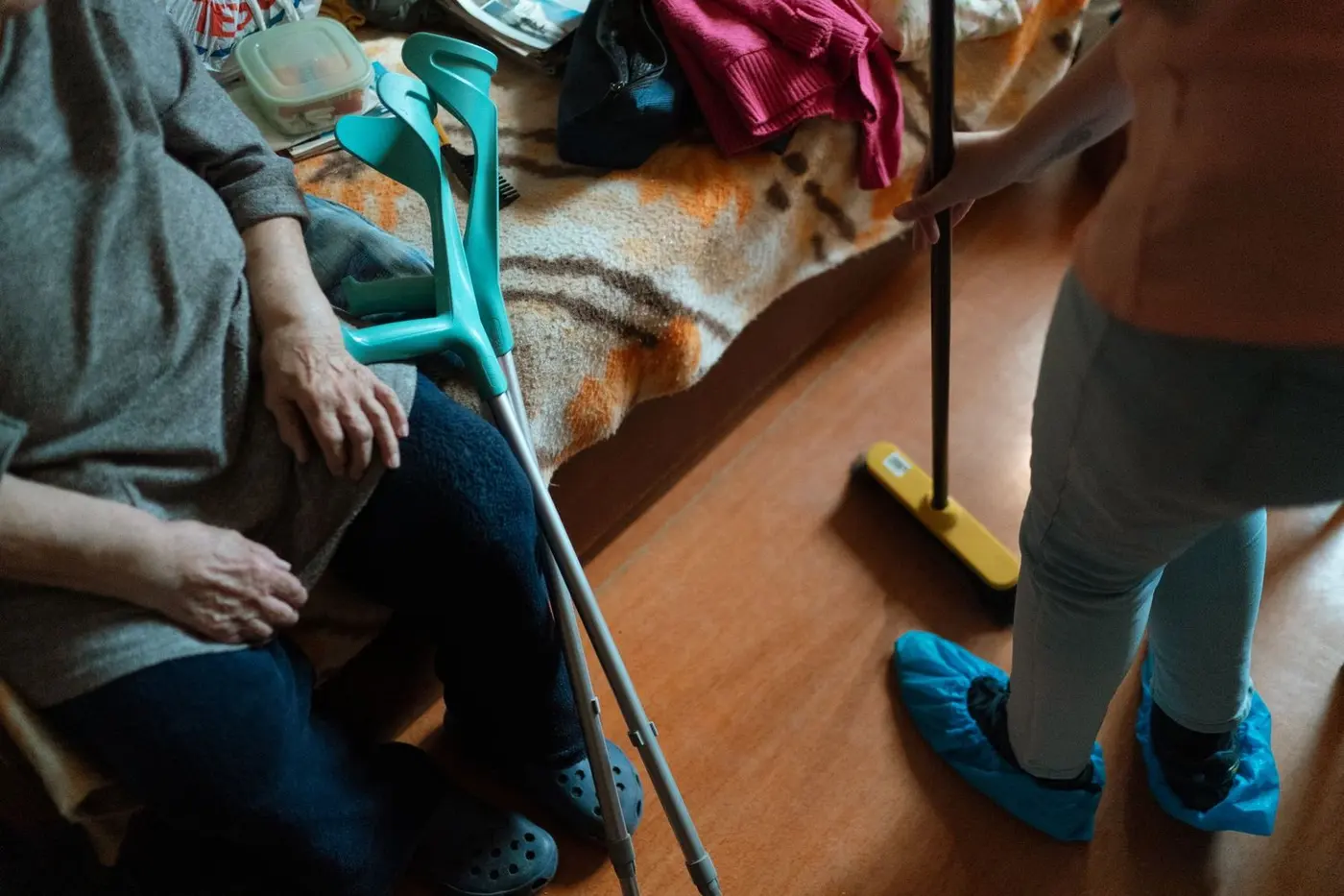 Úklid pro seniory: důvěra a pravidla Starší žena a známá pomocnice společně řeší běžný úklid v domácnosti.
