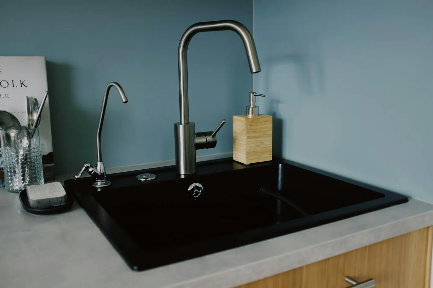 Drain odor: fixes and warning signs Čistý kuchyňský dřez s chromovou baterií v moderním bytě.
